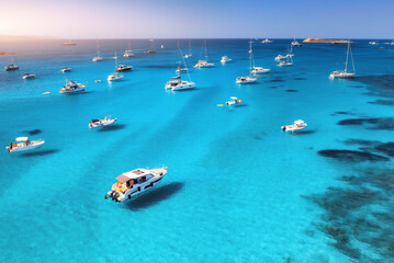 Aerial view of luxury yachts on blue sea at sunset in summer. Sardinia, Italy. Aerial view of speed...