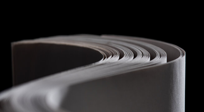 sheets white paper edge flow wave shape on black copy space empty background