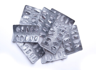 Used empty pill blister pack, discarded silver medicine packs, isolated on white background