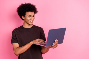 Photo of young curly hair guy junior level programmer it specialist using netbook writing code line isolated over pink color background