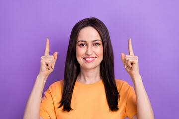 Photo of cheerful woman with straight hairdo dressed orange t-shirt indicating at logo empty space...