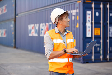 factory worker or engineer working on laptop computer in containers warehouse storage