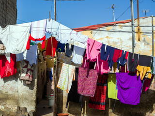 Du linge sèche dans une rue de la ville de Saint Louis du Sénégal en Afrique de l'Ouest - obrazy, fototapety, plakaty