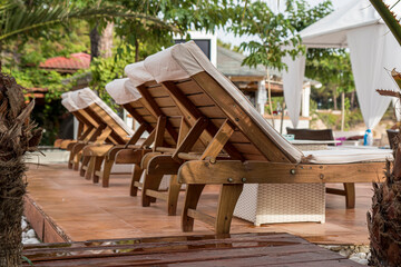 Sun umbrellas and sun beds on beautiful sandy beach at low angle.
