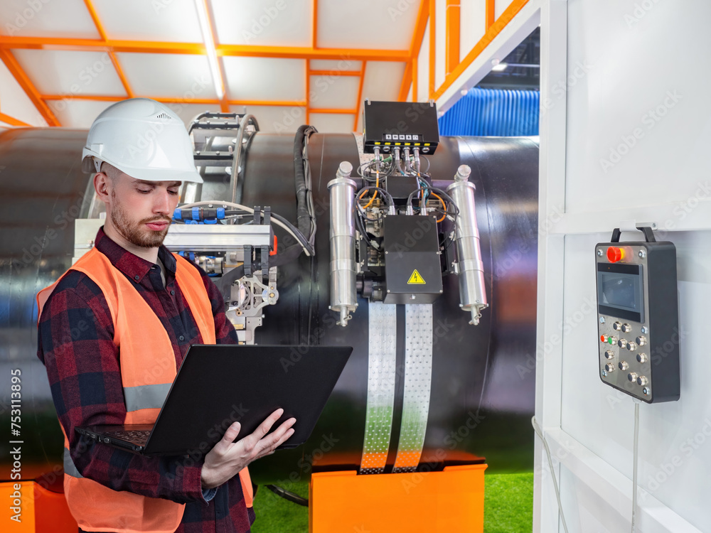 Poster man engineer. production of large diameter pipes. worker controls robot for soldering pipes. welding