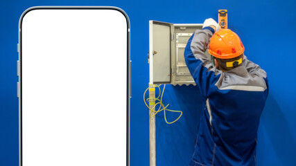 Man is electrician. Phone mock up. Electrician man repairs power panel. Repairman with back to camera. Smartphone with blank screen. Phone for ads electrician services. Electrical cabinet repair