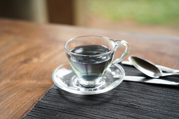Blue tea is served in a nice glass cup at the breakfast table.           