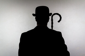 Backlit Portrait of English Gentleman in Bowler Hat Holding Umbrella. Vintage Style of British Spy...