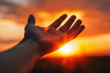 A person holding their hand up towards the sun against a bright sunset sky.