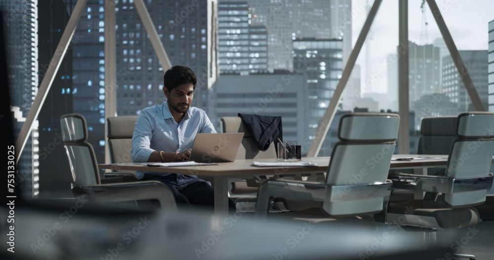 Poster indian executive manager working in a business research and development office on a laptop computer.