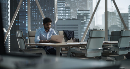 Indian Executive Manager Working in a Business Research and Development Office on a Laptop...