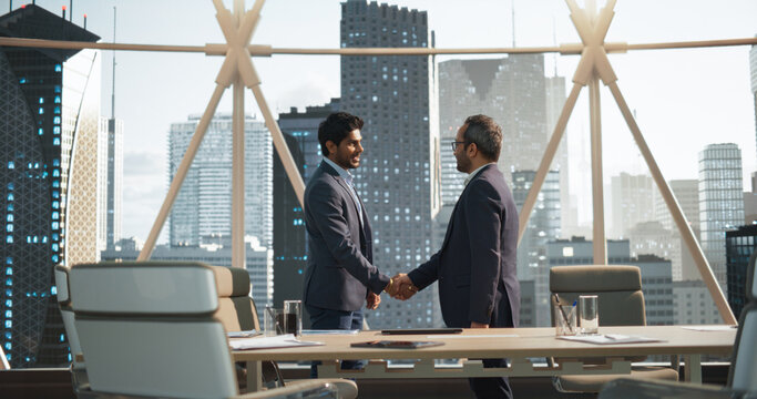 Two Young South Asian Businessmen Shaking Hands in Corporate Office Conference Room. Operations Manager and Team Leader Discussing Creative Business Solutions for Their Company Project