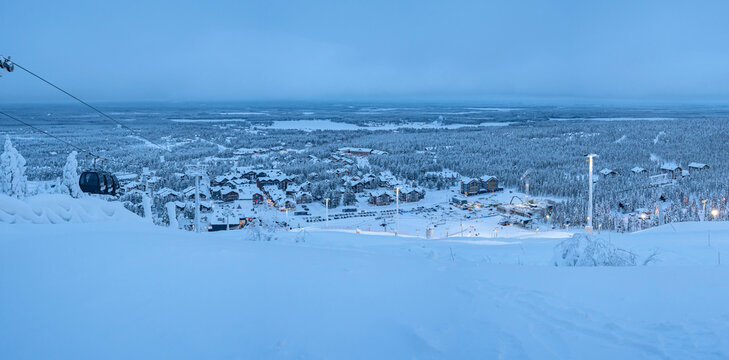 Panoramic view from the ski slope of the village of Levi, Finland, covered with snow in the evening lights.

