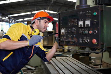 engineer or technician fixing lathe machine in the factory