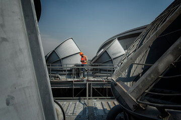 Engineer under checking the industry cooling tower air conditioner is water cooling tower air chiller HVAC of large industrial building to control air system.