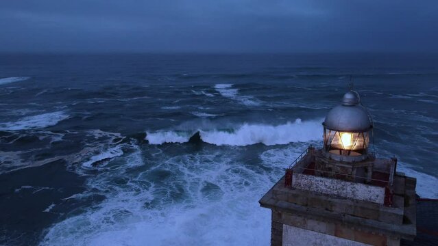 Close-up of the Luarca lighthouse in Asturias with the enraged Cantabrian sea.