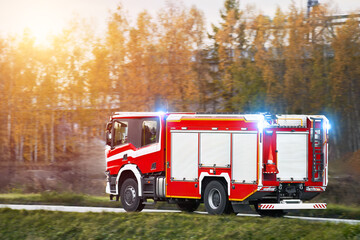 Firefighters in action on a firetruck. They drive a vehicle with fire equipment and siren. They are...