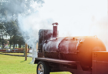 Large barbecue smoker grill at the park. Unleashing Flavors Amidst the Greens with a Hearty BBQ...