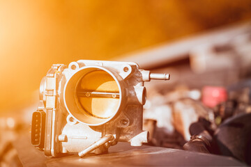 The electronic throttle body and modern car underhood with opposed engine in the background. Engine...