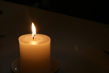 A candle glowing in the dark. 