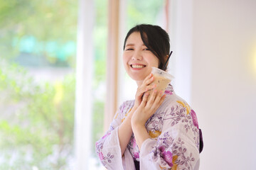 Japanese woman smile with yukata dress and milk tea in hand
