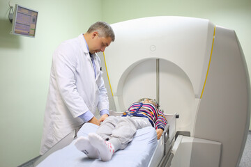  The attending physician prepares the patient for the procedure on the Gamma Knife in the...