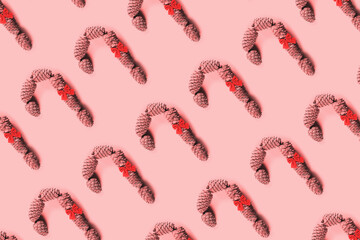 Caramel cane with bow of cedar cones for decoration. Pattern.