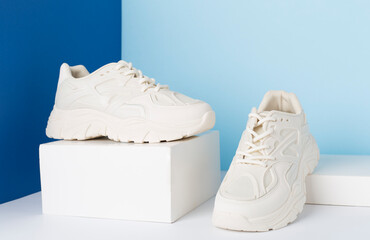 White woman trendy sneakers on color background