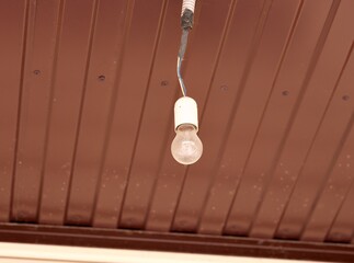A dusty light bulb hanging from a ceiling
