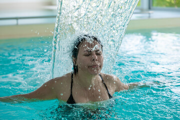 Woman Face Relax in a Hydromassage Pool with Falling Water in Switzerland.
