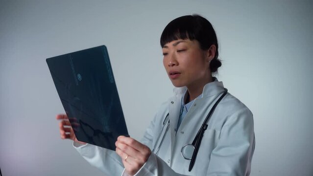Medium shot of intellectual woman healthcare personnel with white lab coat, looking at full body x-ray radiographic image, ct scan, mri, isolated hospital clinic background. Radiology department