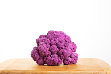 Purple cauliflower on a wooden board on a white background