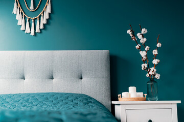 Stylish modern bedroom in dark colors. Cozy interior with blue turquoise walls, home decor. Bed...