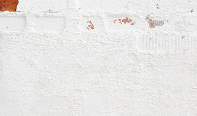 Old white brick wall background with rough plaster texture. Rough white plaster wall surface. Grunge wallpaper.