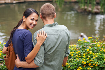 Couple, hug and love or portrait at park, relationship and care on outdoor adventure or holiday. People, happy and embrace on vacation and romance at sanctuary, zoo and calm or peace on weekend trip