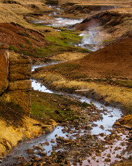 Winding thermal river through colorful ground soil in Iceland