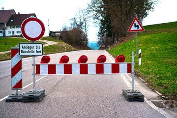Red and white work in progress sign of a barred road in reconstruction.