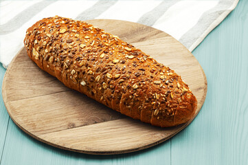 black sliced bread with bran on a blue table. oval dark bread on light texture	