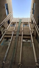 Residential appartment building plumbing and water supply, distribution and circulation system plastic pipes on wall. Pipelines and drainage concept. Closeup vertical bottom view