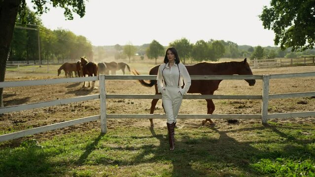 Modern Equestrian Fashion. Fashion-forward woman stands confidently at horse ranch.