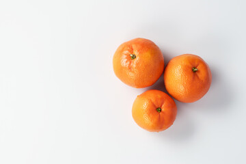 Tangerines or clementines are laid out on a white background