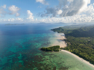 Clear water with corals and ocean waves in Duli Beach. El Nido, Philippines.