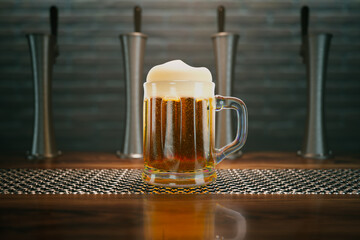 Cold beer mug full of delicious liquid standing on a bar counter in a spotlight