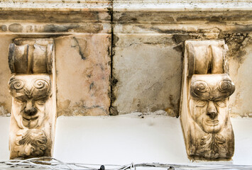Carved stone faces of demons on balcony in Elvas