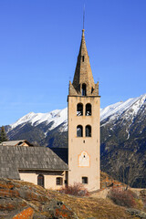 Fototapeta na wymiar Bell tower of the church of Saint Peter in Puy-Saint-Pierre, a hillside Alpine village located above Briançon in the Hautes Alpes department of the French Alps, France