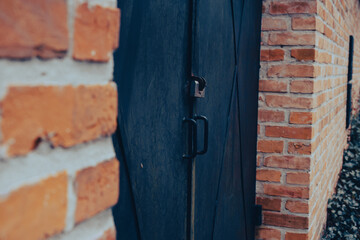 Obraz na płótnie Canvas a door is seen between two brick buildings as well as gravel