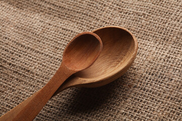 Wooden spoons on burlap background close up