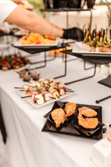 woman hands of a waiter prepare food for a buffet table in a restaurant