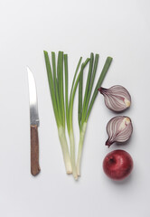 Red and green onions with knife on a white background. Top view