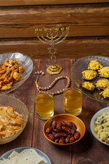Shabbat table for a family meal with traditional holiday dishes on the table, rosary and menorah